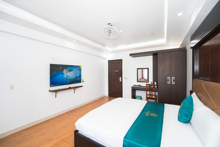 Phòng giường đôi nhìn từ phía chân giường, có TV, tủ quần áo và bàn trang điểm