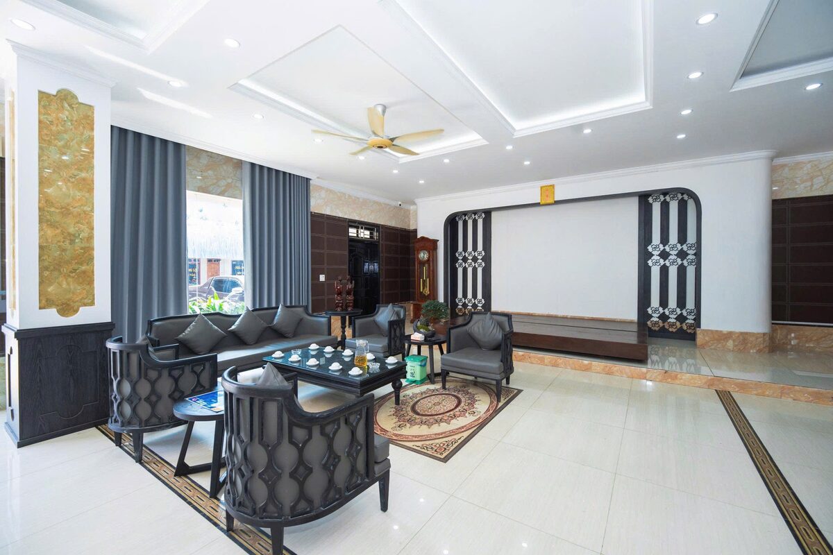 Khu tiếp khách tại sảnh lễ tân với ghế sofa, bàn trà và quạt trần