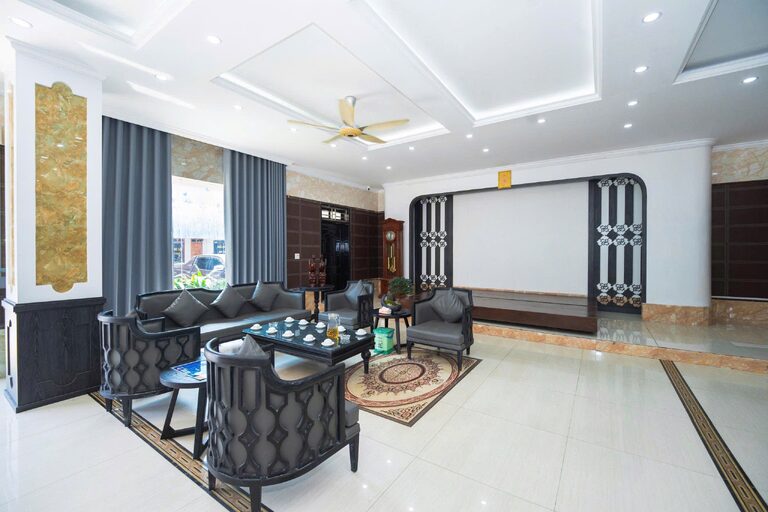 Khu tiếp khách tại sảnh lễ tân với ghế sofa, bàn trà và quạt trần